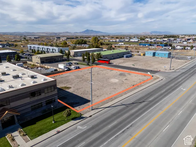 Corner commercial lot featuring high-visibility road frontage, level topography, and prominent mountain backdrops