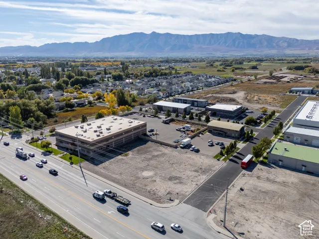 Commercial property featuring a multi-story building, paved parking surface, and mountain backdrop