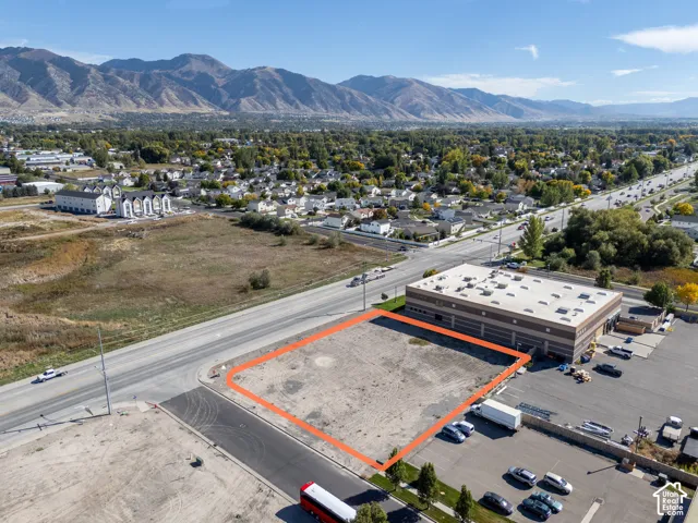 Cleared commercial land parcel featuring paved street frontage and prominent mountain backdrops
