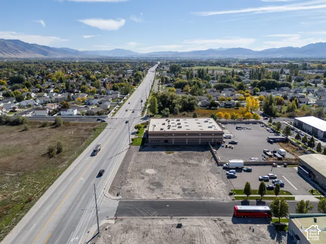 Commercial property featuring paved parking area, masonry building construction, and direct access to a multi-lane thoroughfare with mountain surroundings