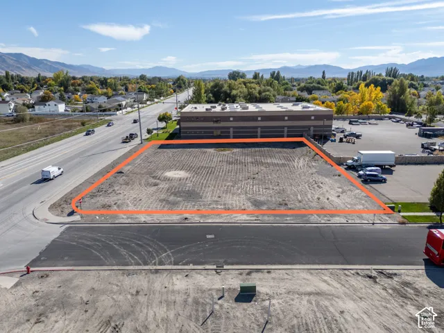 Level lot featuring paved road access, frontage on a main thoroughfare, and a backdrop of mountain scenery