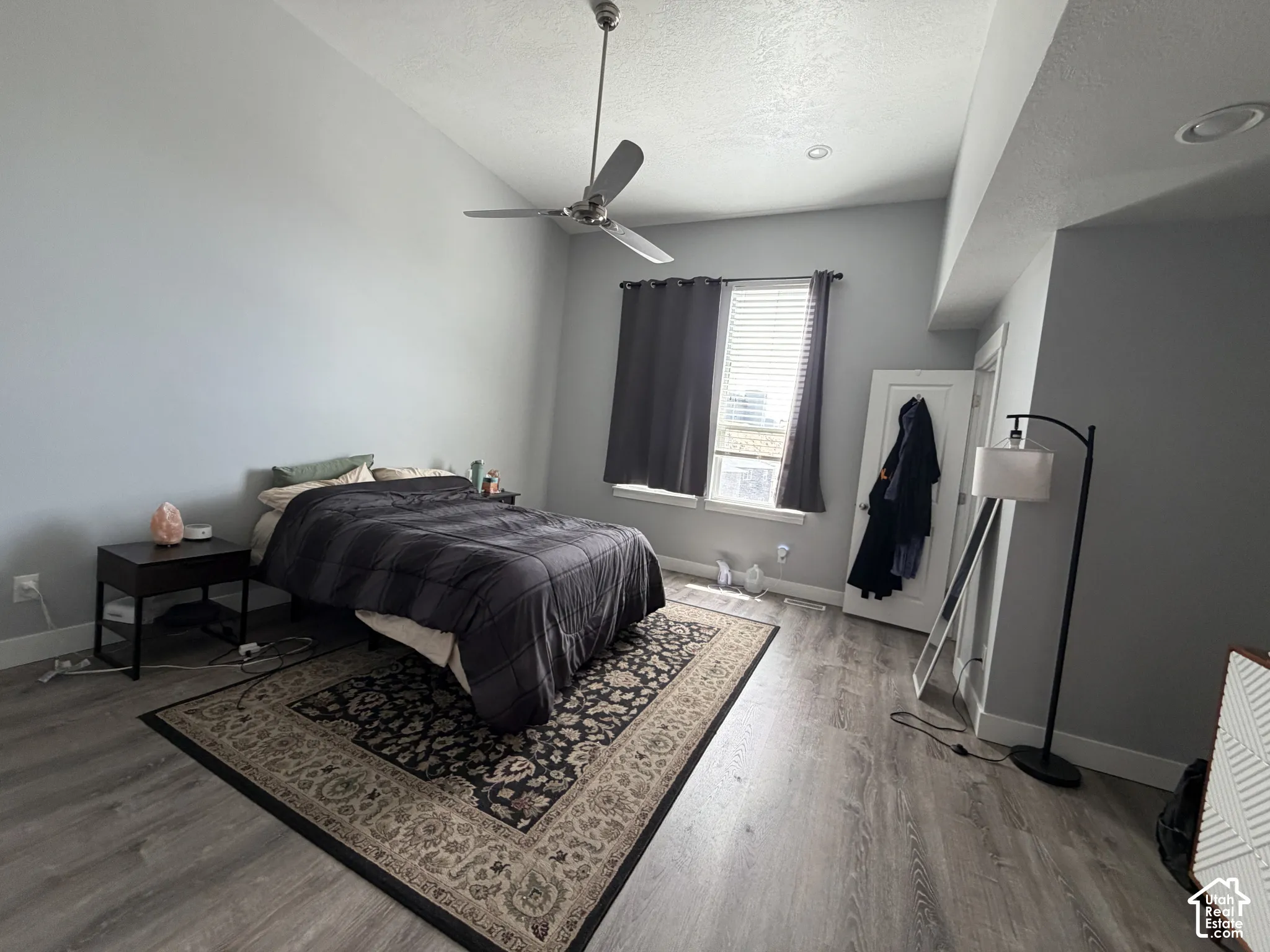 Vaulted ceilings, wood-finish flooring, brushed metal ceiling fan, and recessed lighting