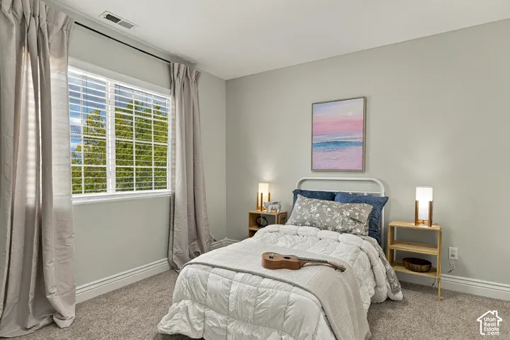 Neutral wall paint, multi-pane window with grid pattern, and neutral wall-to-wall carpeting