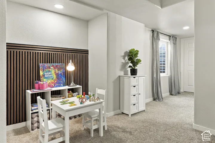 Interior space featuring wall-mounted vertical wood slat paneling, recessed lighting, and wall-to-wall carpeting