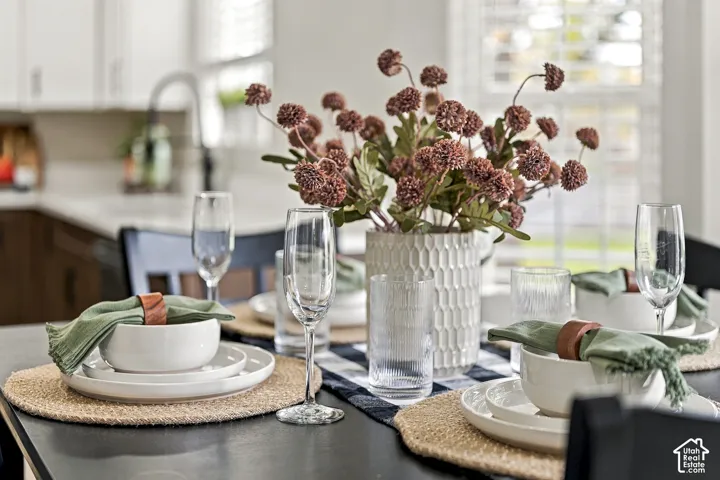 Kitchen featuring white cabinetry, light-toned countertops, and multi-pane windows with adjustable interior shutters