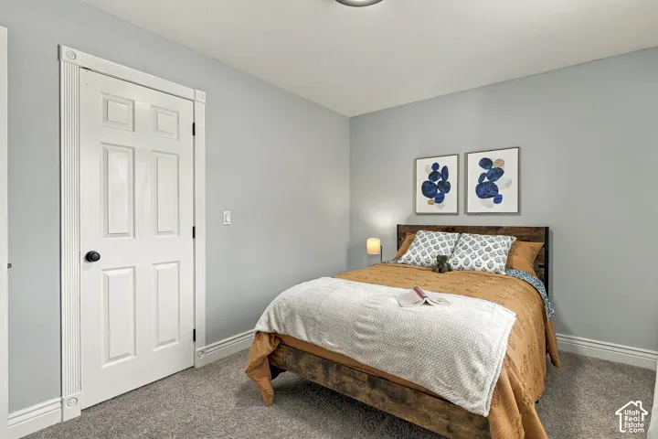 Room featuring neutral wall paint, plush carpeting, and a six-panel door with decorative casing blocks