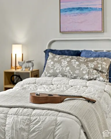 Neutral-toned interior space featuring a matte white metal bed frame