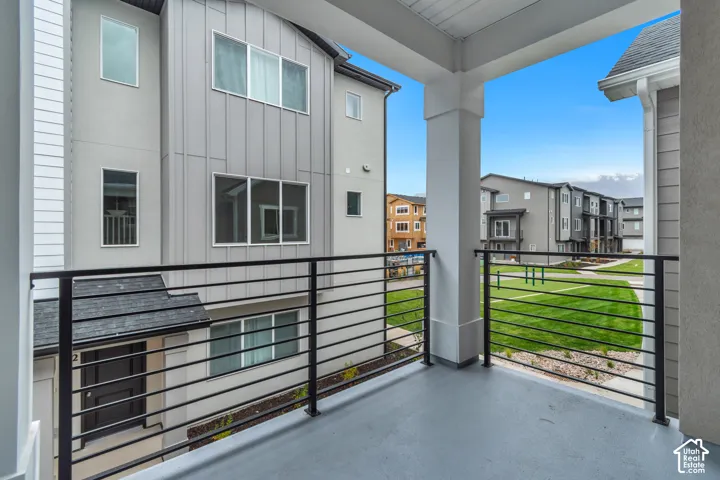 Covered balcony featuring horizontal metal railings, concrete flooring, and vertical siding exterior
