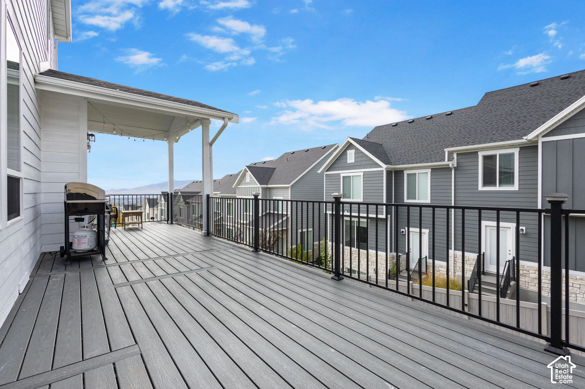 Covered composite deck featuring black metal railing and mountain scenery