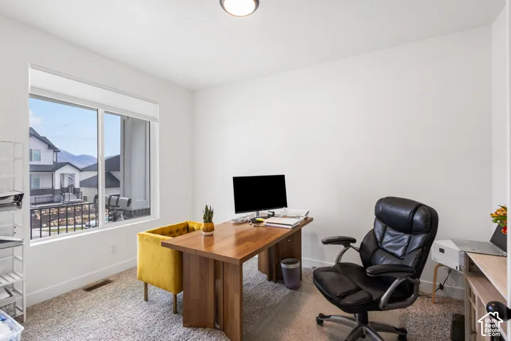 Room featuring neutral-toned carpeting, crisp white walls, and a large sliding window with exterior mountain scenery