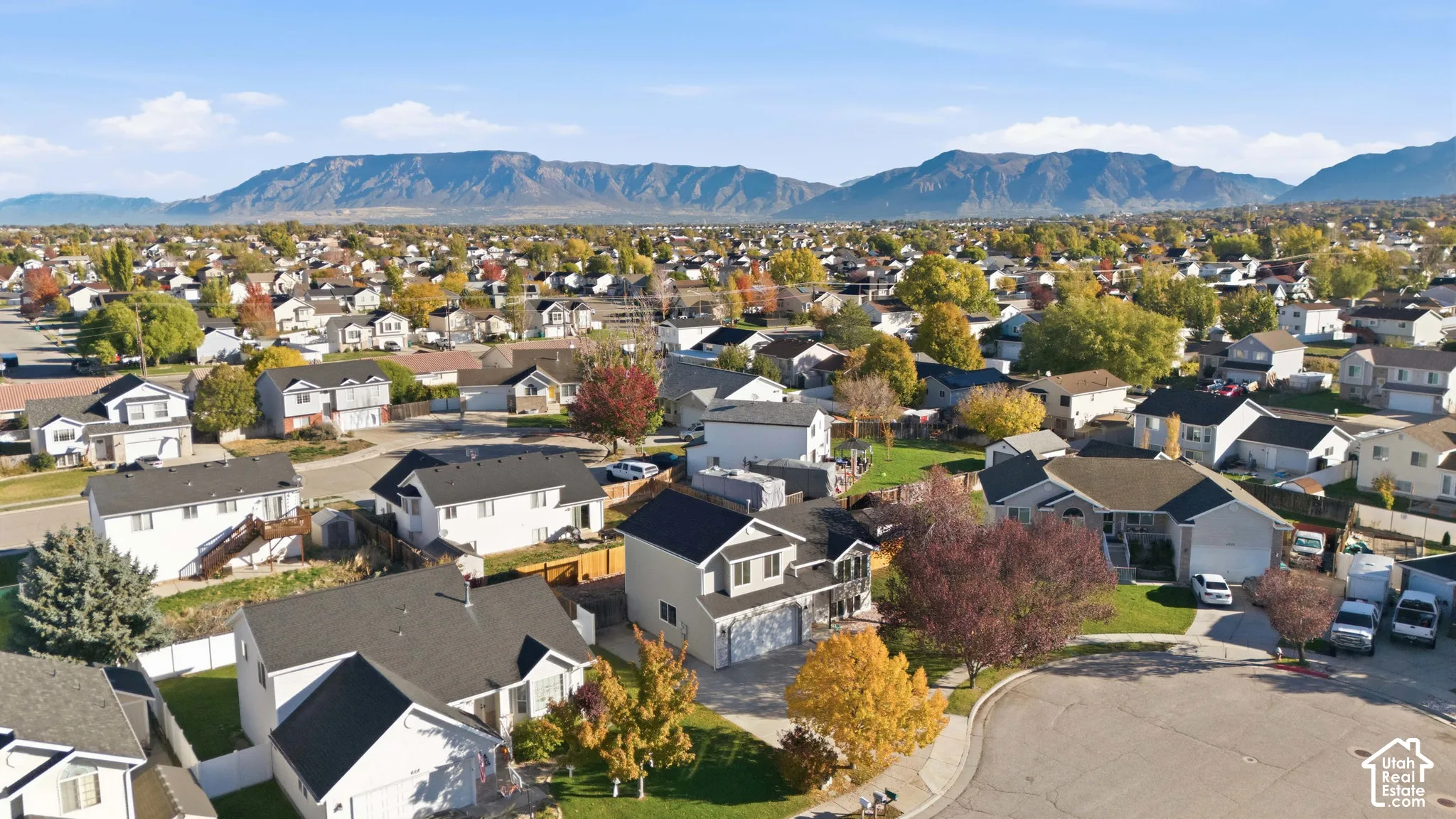 Aerial perspective featuring residential lots, paved streets, and a prominent mountain backdrop