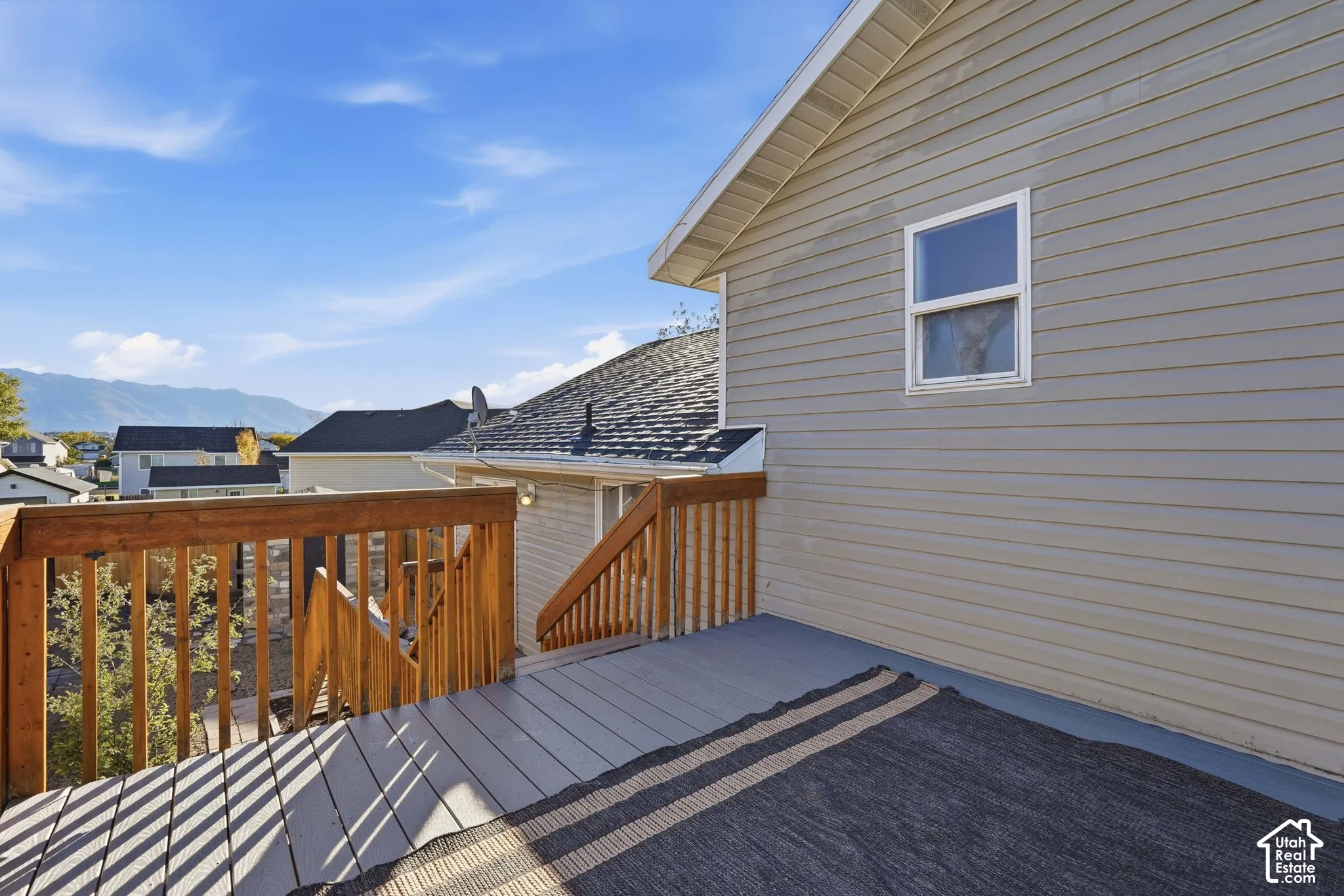 Elevated exterior deck featuring horizontal wood-finish railings, wood-plank flooring, and stairs