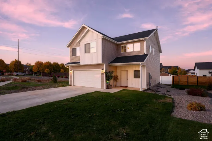 Two-story residence featuring horizontal and vertical siding, a composition shingle roof, a two-car garage, and a concrete driveway