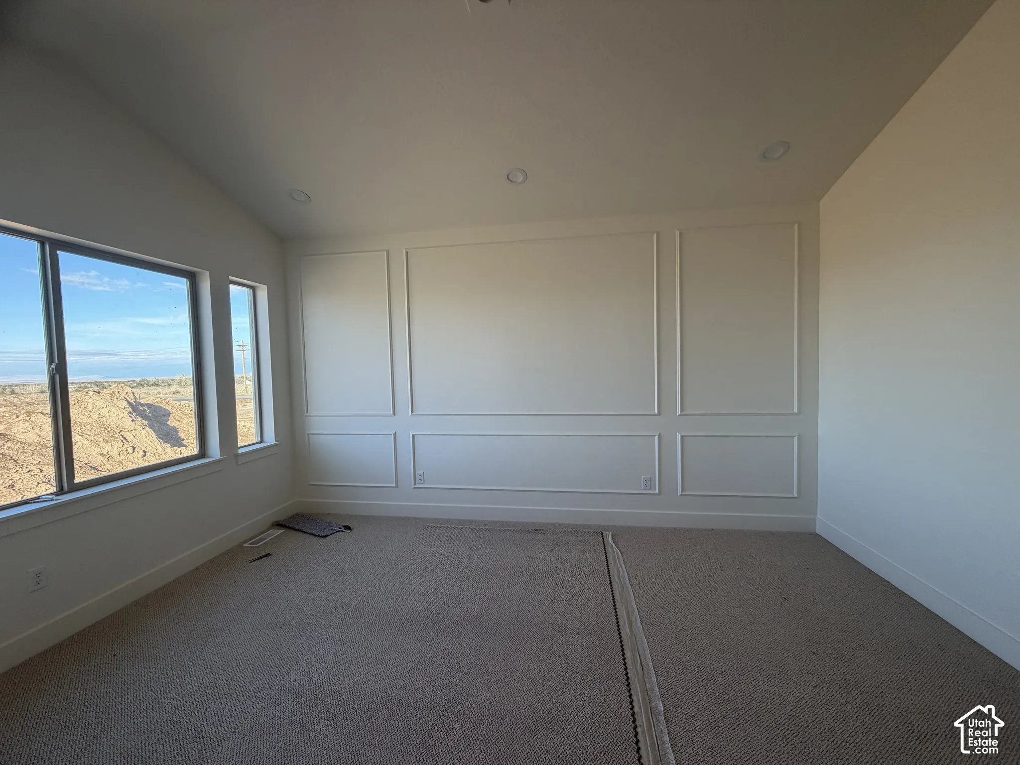 Room featuring decorative wall molding, recessed lighting, carpeted flooring, and multiple windows