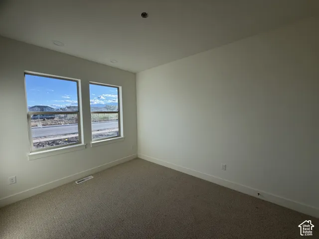 Neutral-toned wall-to-wall carpeting, two dual-pane windows, and recessed lighting