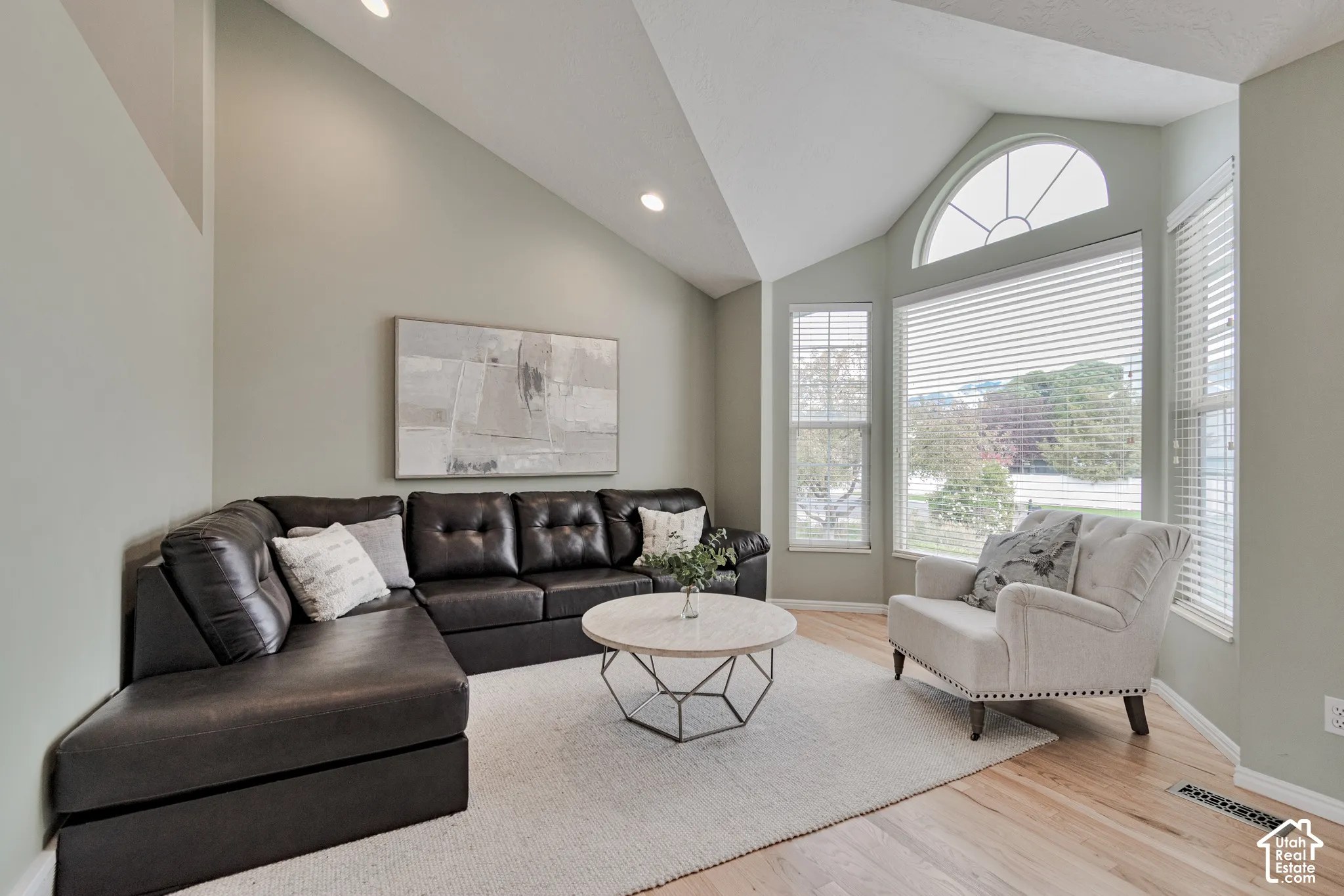 Vaulted ceilings featuring recessed lighting, bay window configuration, semi-circular transom window, and wood-finish flooring