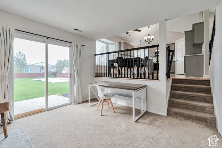 Sliding glass door, neutral carpeting, elevated railing with black balusters, and staircase with carpeted treads
