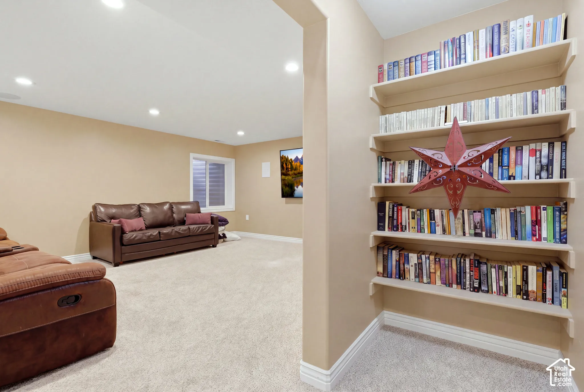 Neutral-toned interior featuring recessed lighting, wall-to-wall carpeting, and floor-to-ceiling built-in shelving