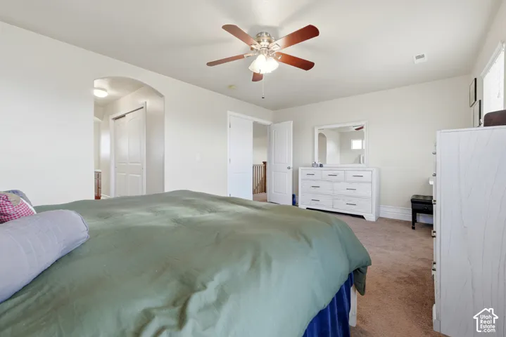 Neutral wall tones, arched interior passage, and a five-blade ceiling fan with integrated light fixture