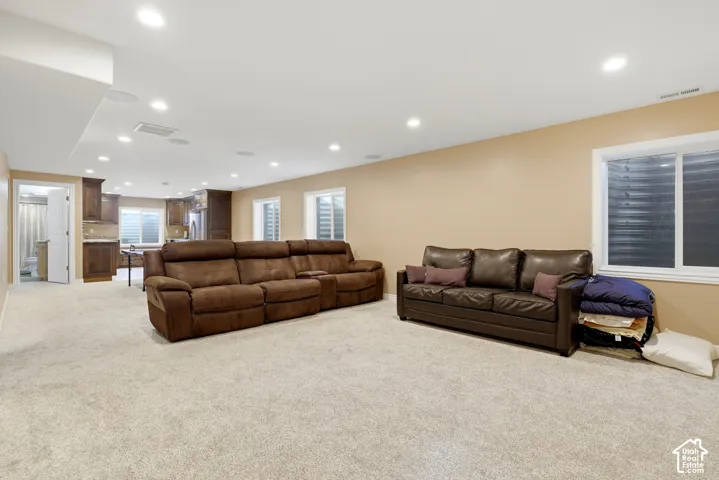 Open-concept interior featuring recessed lighting, wall-to-wall carpeting, multiple egress windows, and dark-finish cabinetry