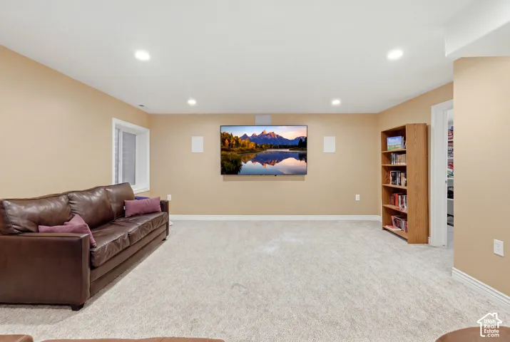 Neutral interior space featuring recessed ceiling lighting, wall-to-wall carpeting, and a built-in wooden shelving unit