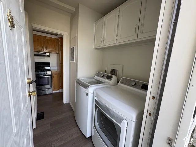 Laundry room featuring overhead cabinetry, wood-finish flooring, and wall-mounted utility hookups