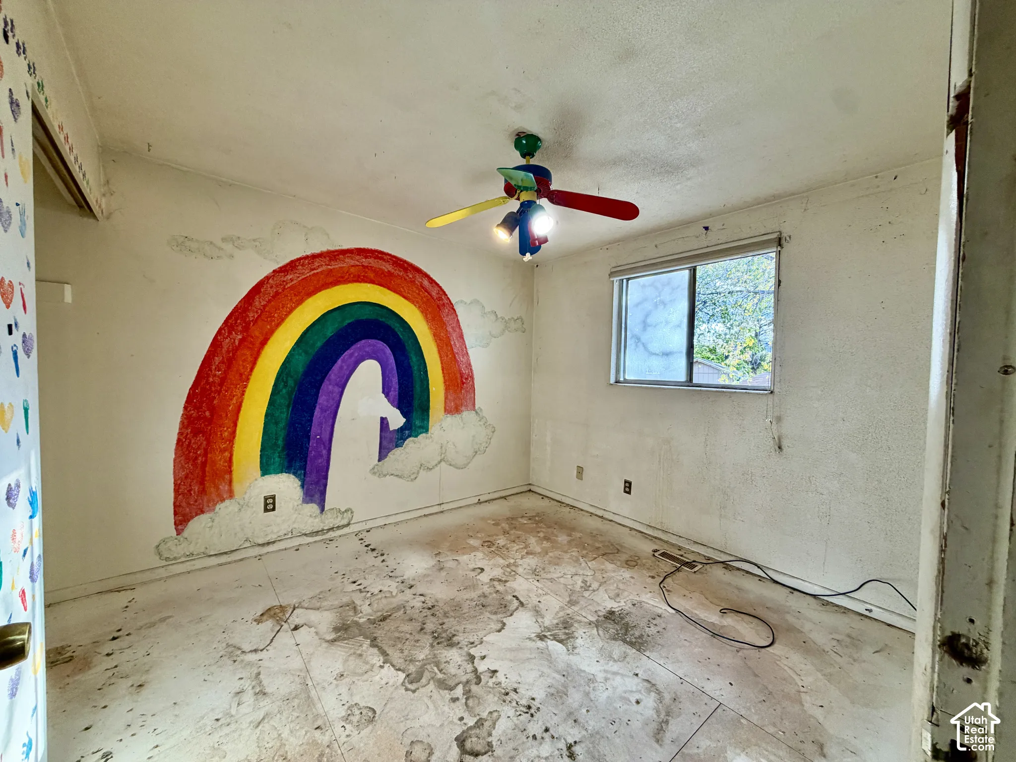 Interior room featuring a window and a multi-colored ceiling fan