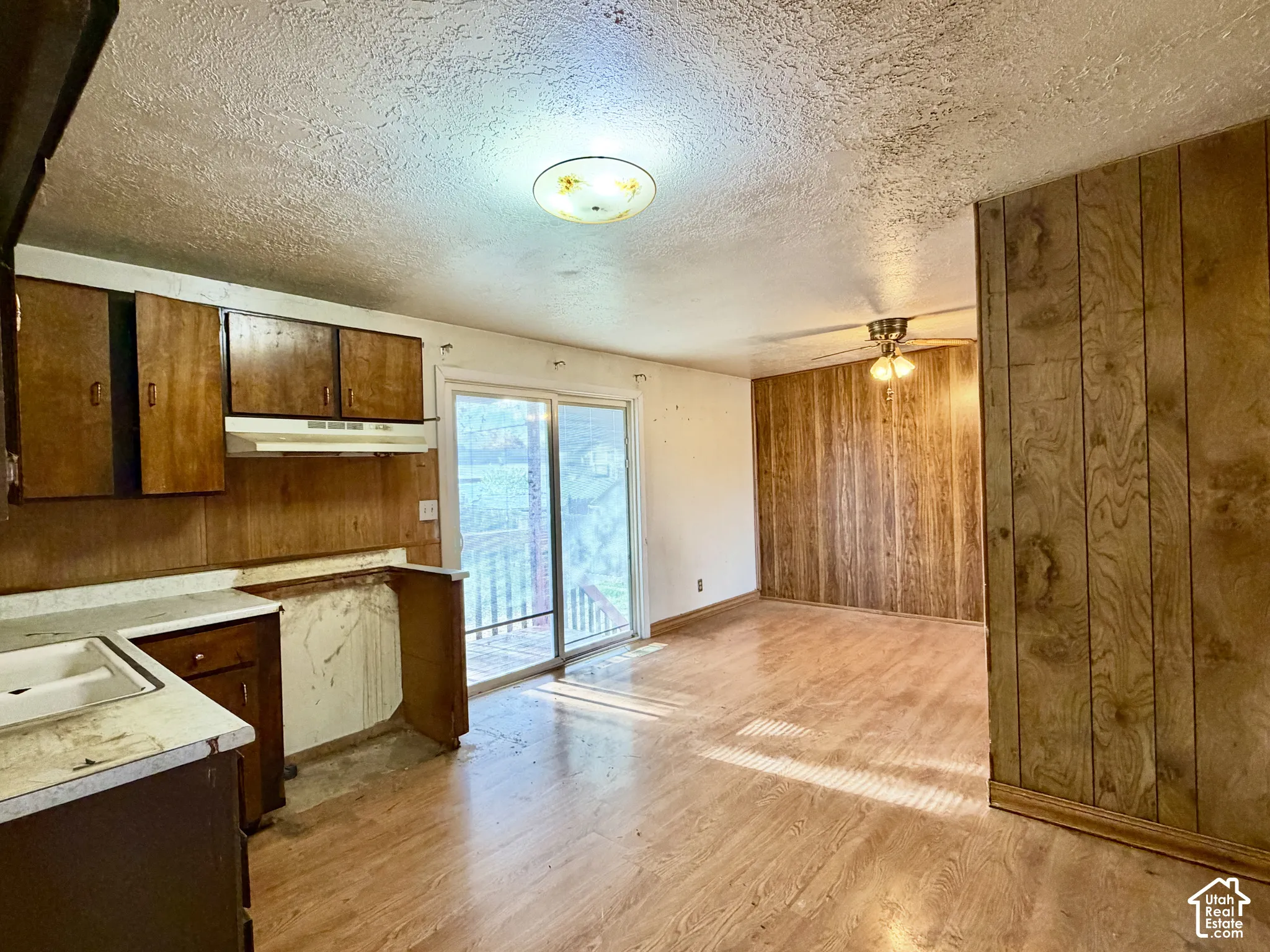 Wood-finish flooring, wood-paneled walls, sliding glass door, and built-in wood cabinetry