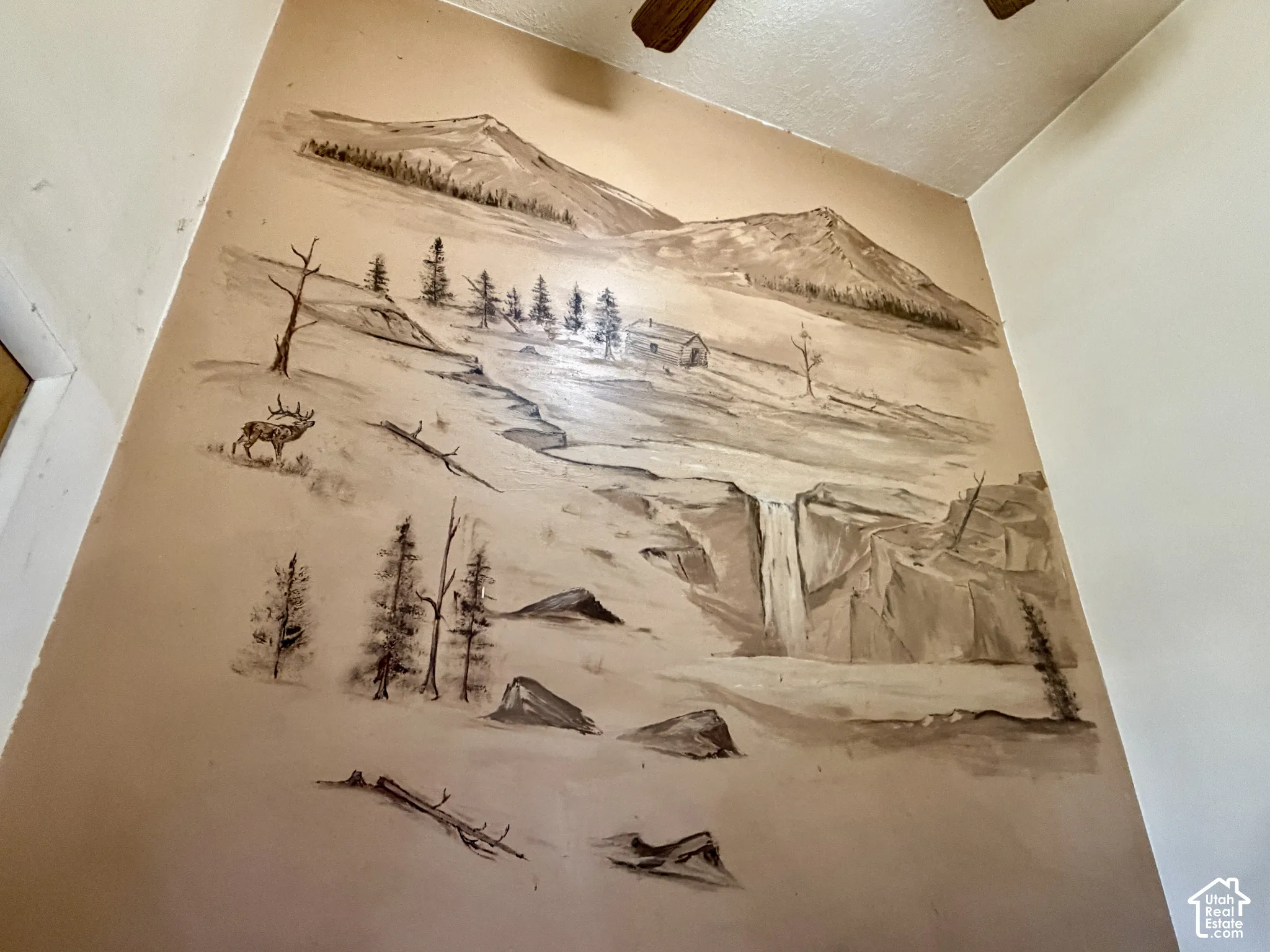 Wall surface featuring a custom, monochromatic mountain-themed mural