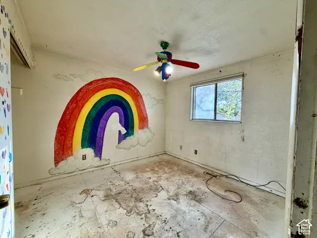 Interior room featuring a window and a multi-colored ceiling fan
