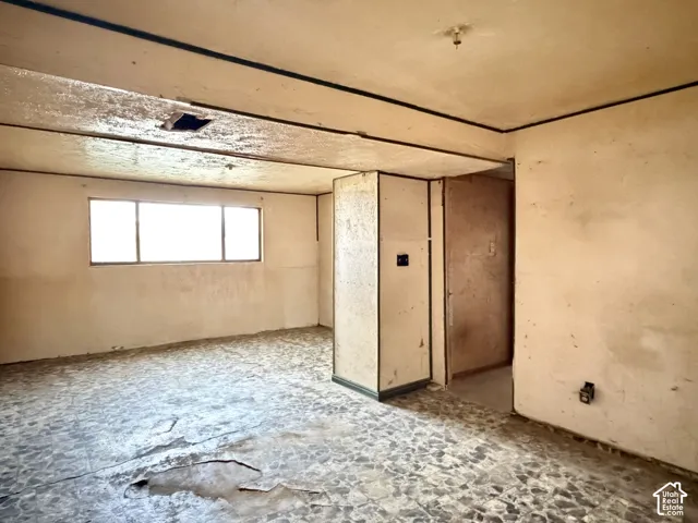 Interior space featuring a window with horizontal muntins and hard-surface tile flooring