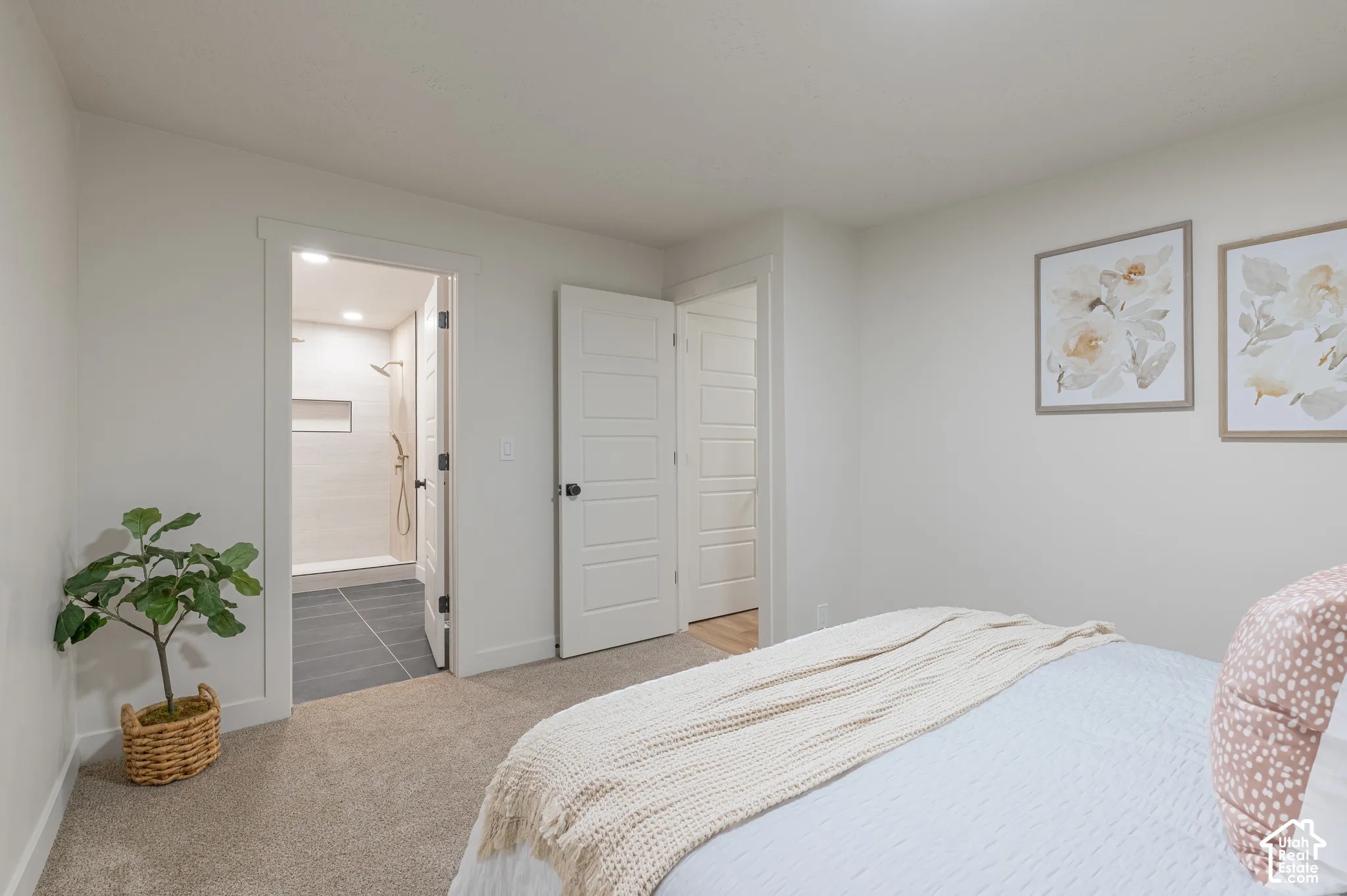Neutral carpeting, solid-core four-panel interior doors, and a bathroom featuring walk-in shower with horizontal wall tile and large-format floor tile