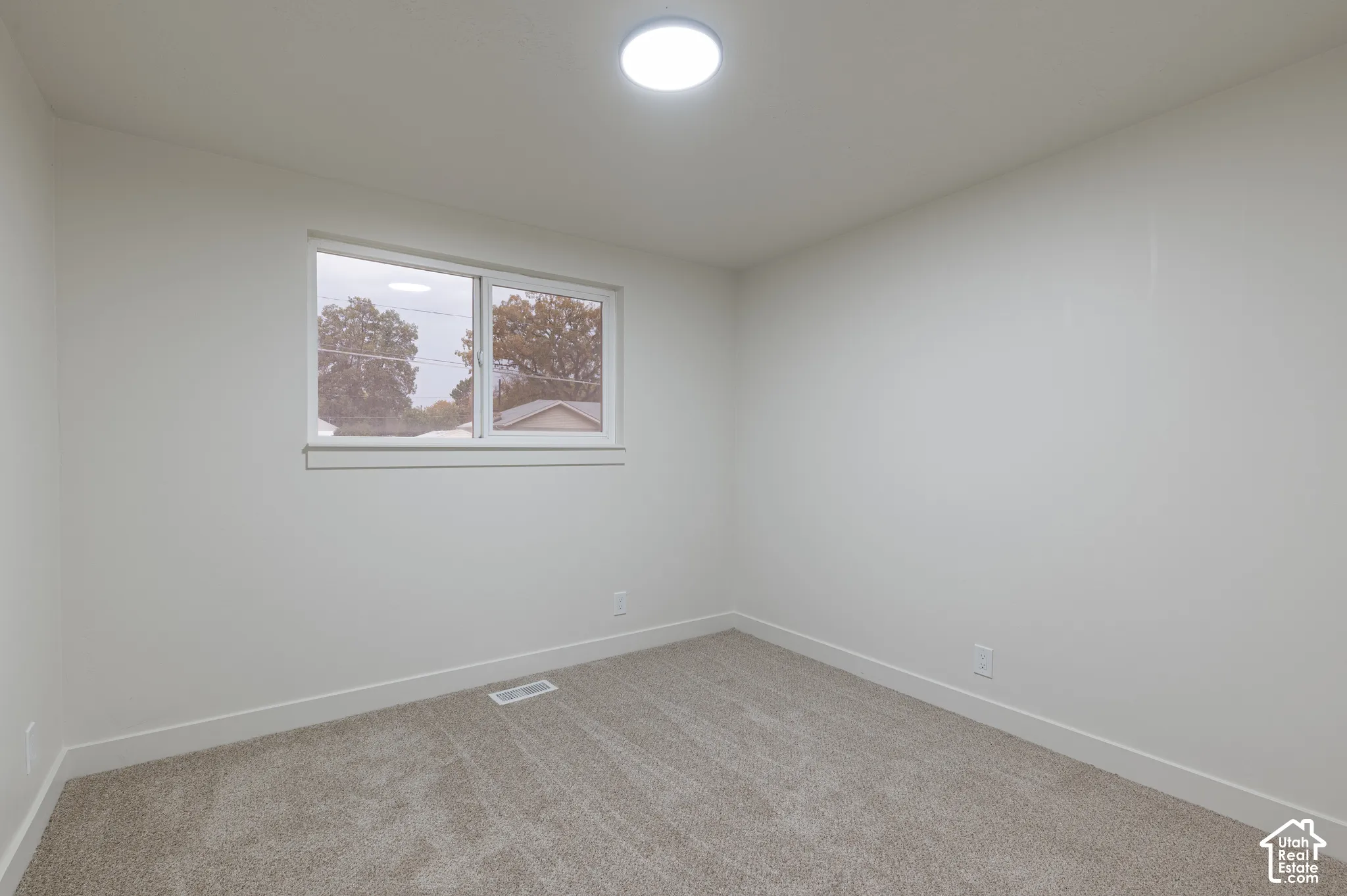 Neutral-toned carpeting, crisp white walls, and a large slider window