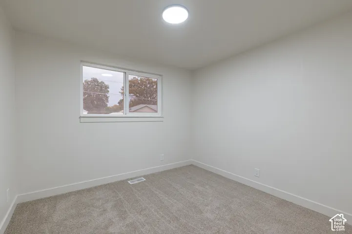 Neutral-toned carpeting, crisp white walls, and a large slider window