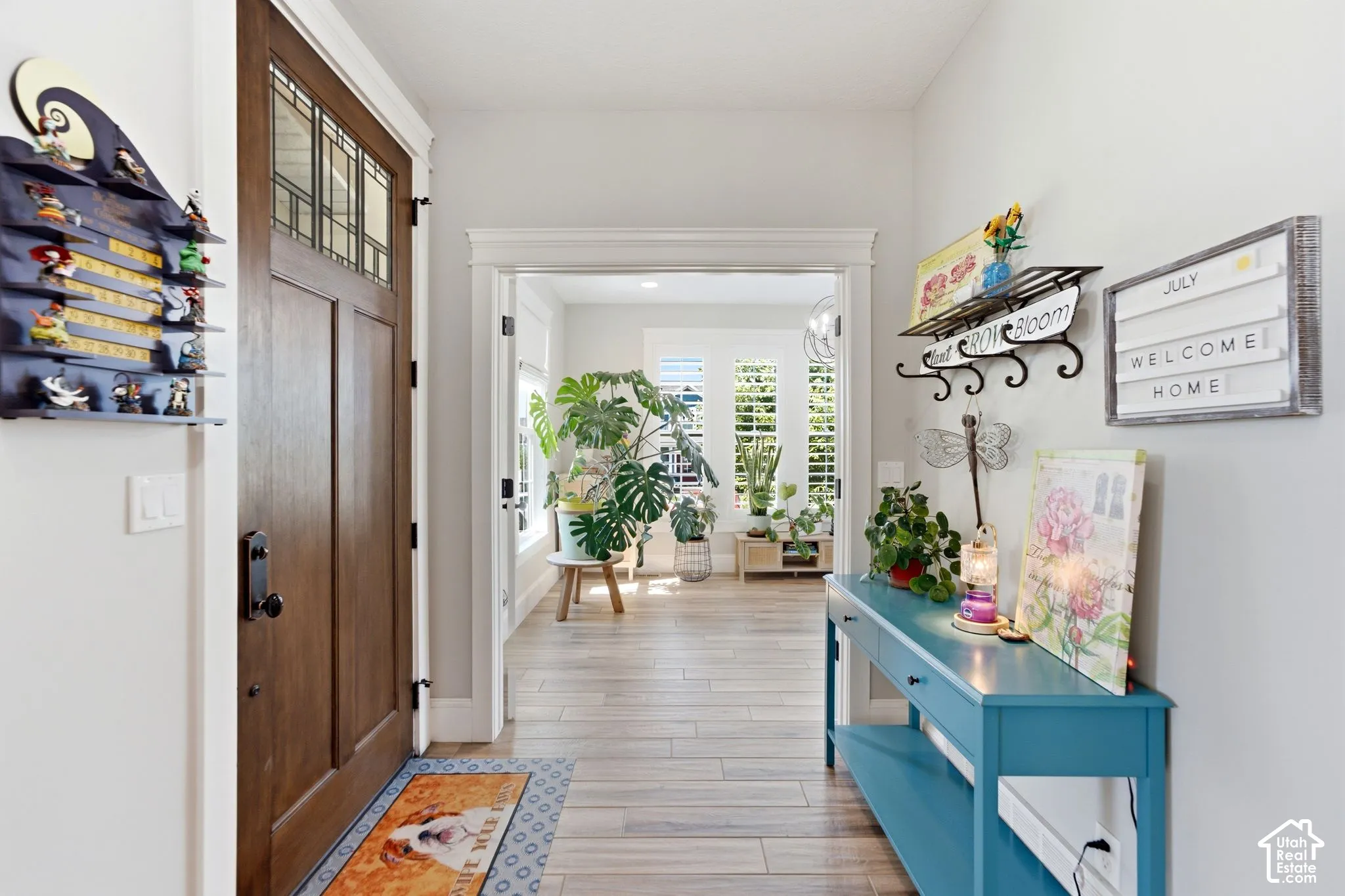 Entryway featuring a solid wood front door with an upper transom glass panel, wide-plank wood looking into office