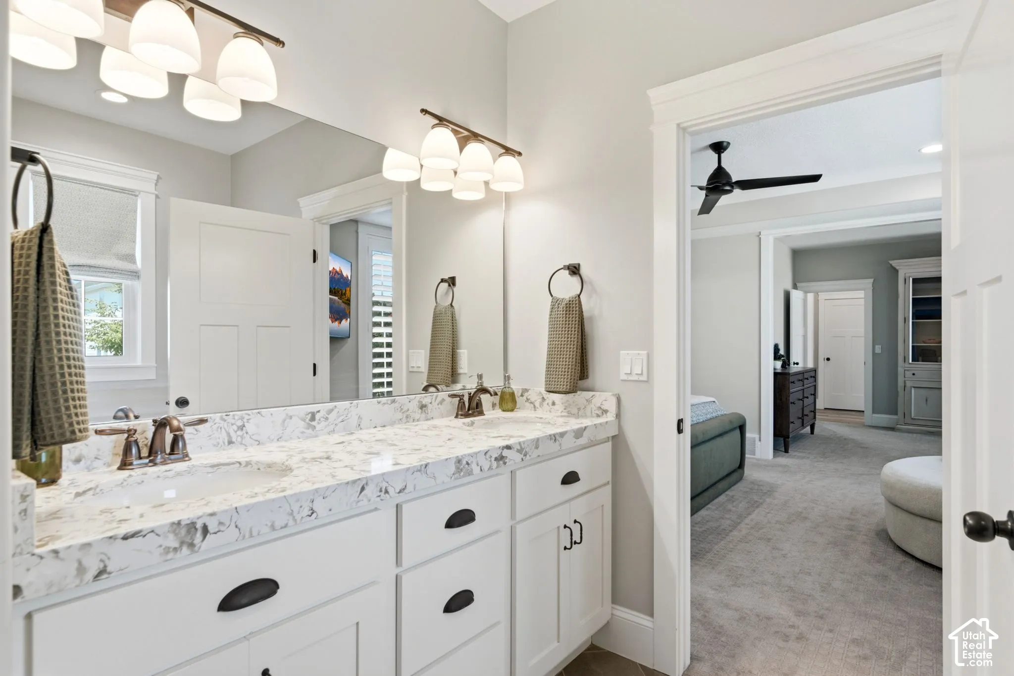 Main level primary suite bathroom -double vanity featuring white cabinetry, dual under-mount sinks