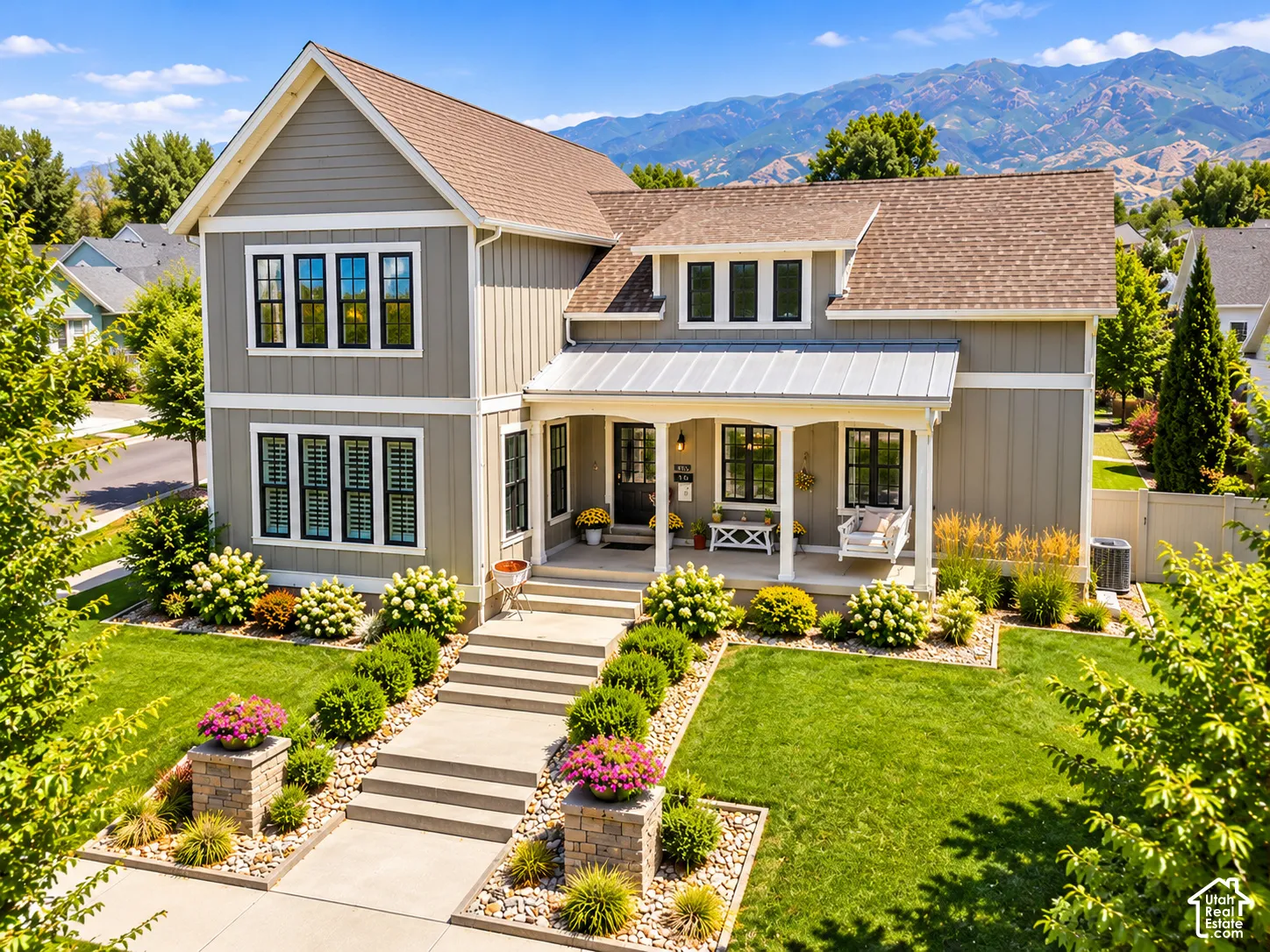 Craftsman-style home featuring a covered front porch and manicured yard