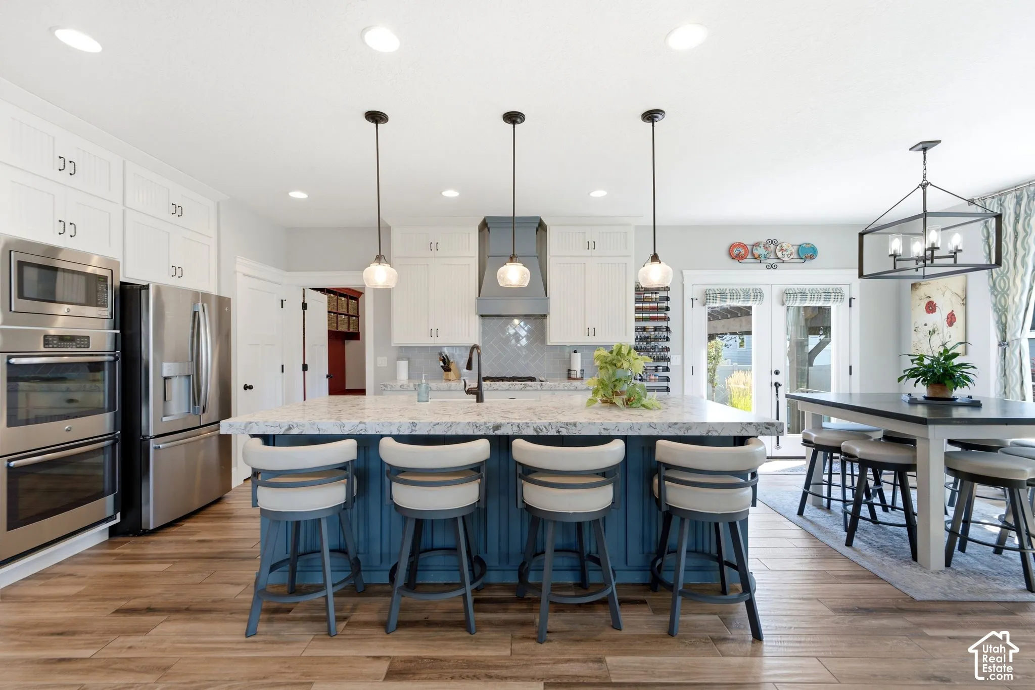 View of main kitchen with double wall ovens, bar and dining area