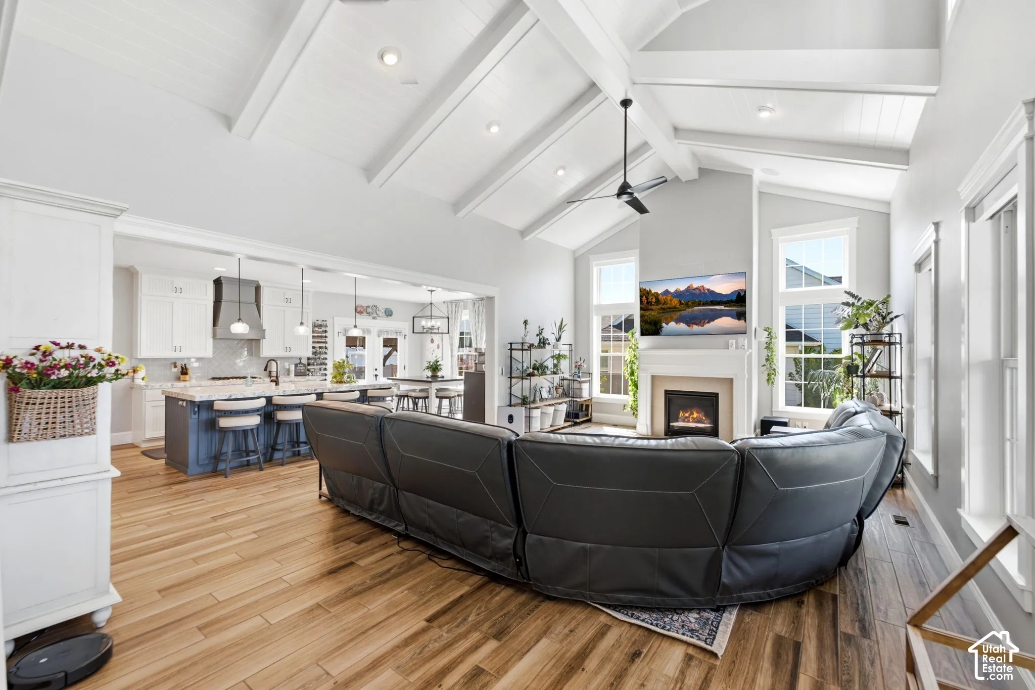 Vaulted ceilings with exposed beams, wood-finish flooring, cozy fireplace