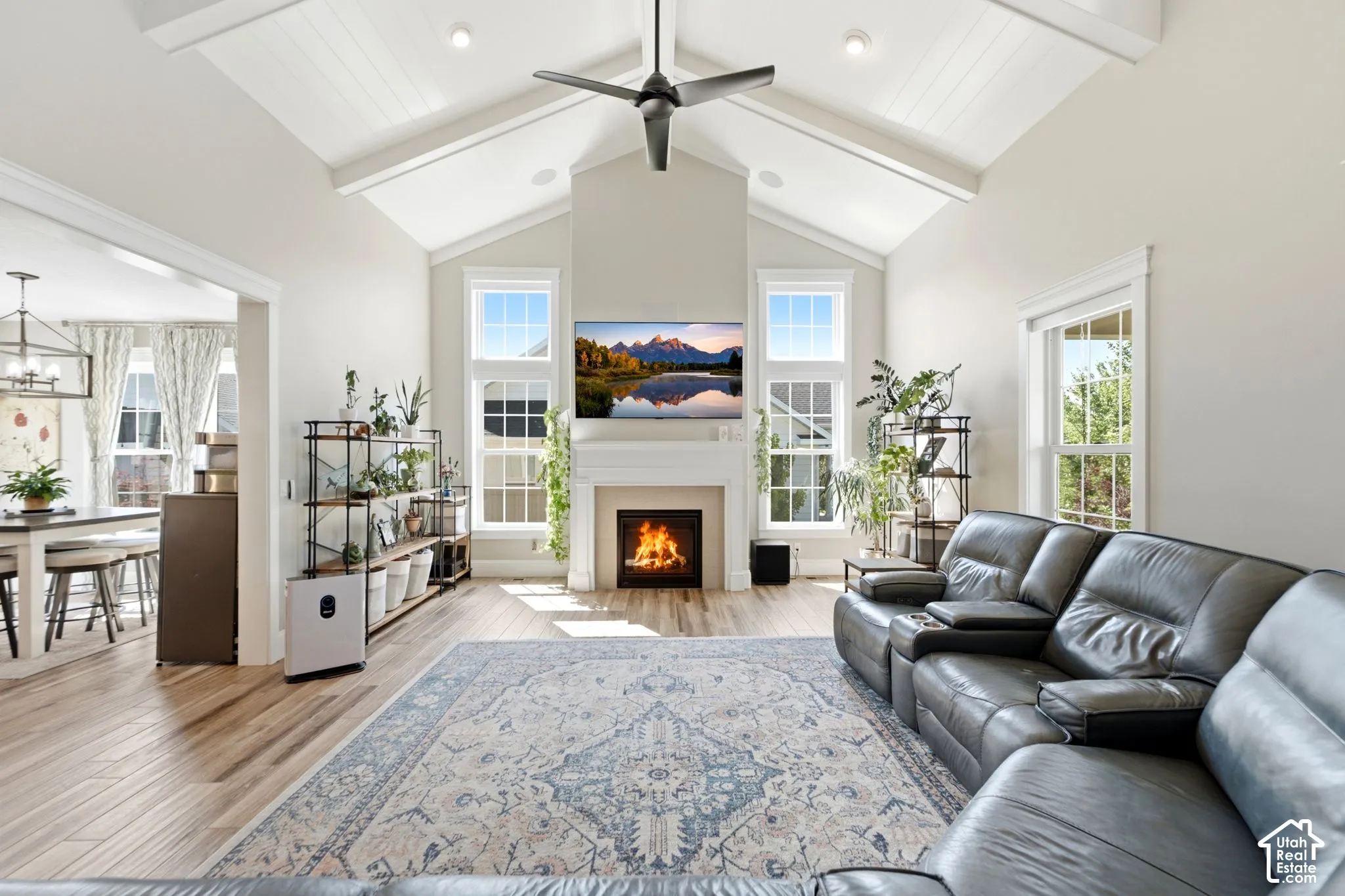 Vaulted ceilings with exposed beams, wood-finish flooring, gas fireplace with mantle, large windows with electric blinds