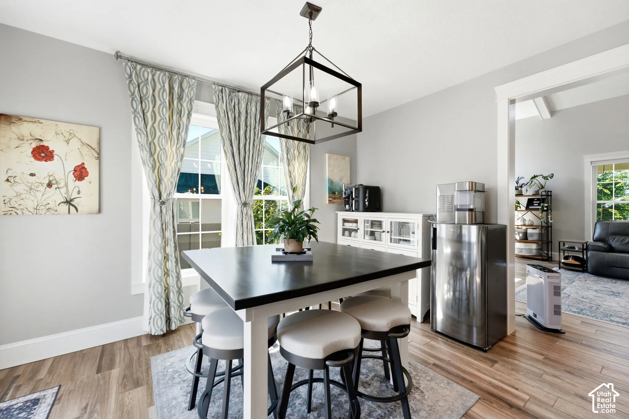 Dining area featuring wood-finish flooring, a geometric metal-frame chandelier, and walks out to back patio