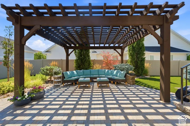 Fenced back yard offers large custom pergola for entertaining or relaxing