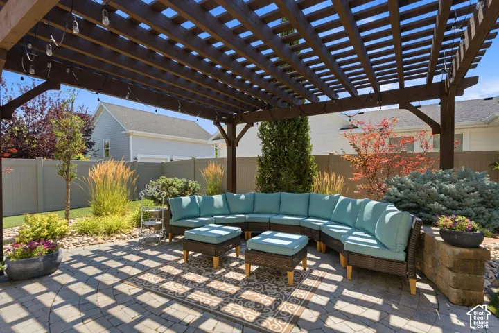 Outdoor patio featuring custom wood pergola, interlocking pavers and full fence