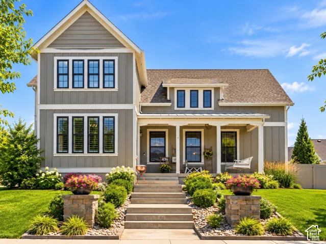 Craftsman-style home featuring a cozy covered front porch and manicured yard