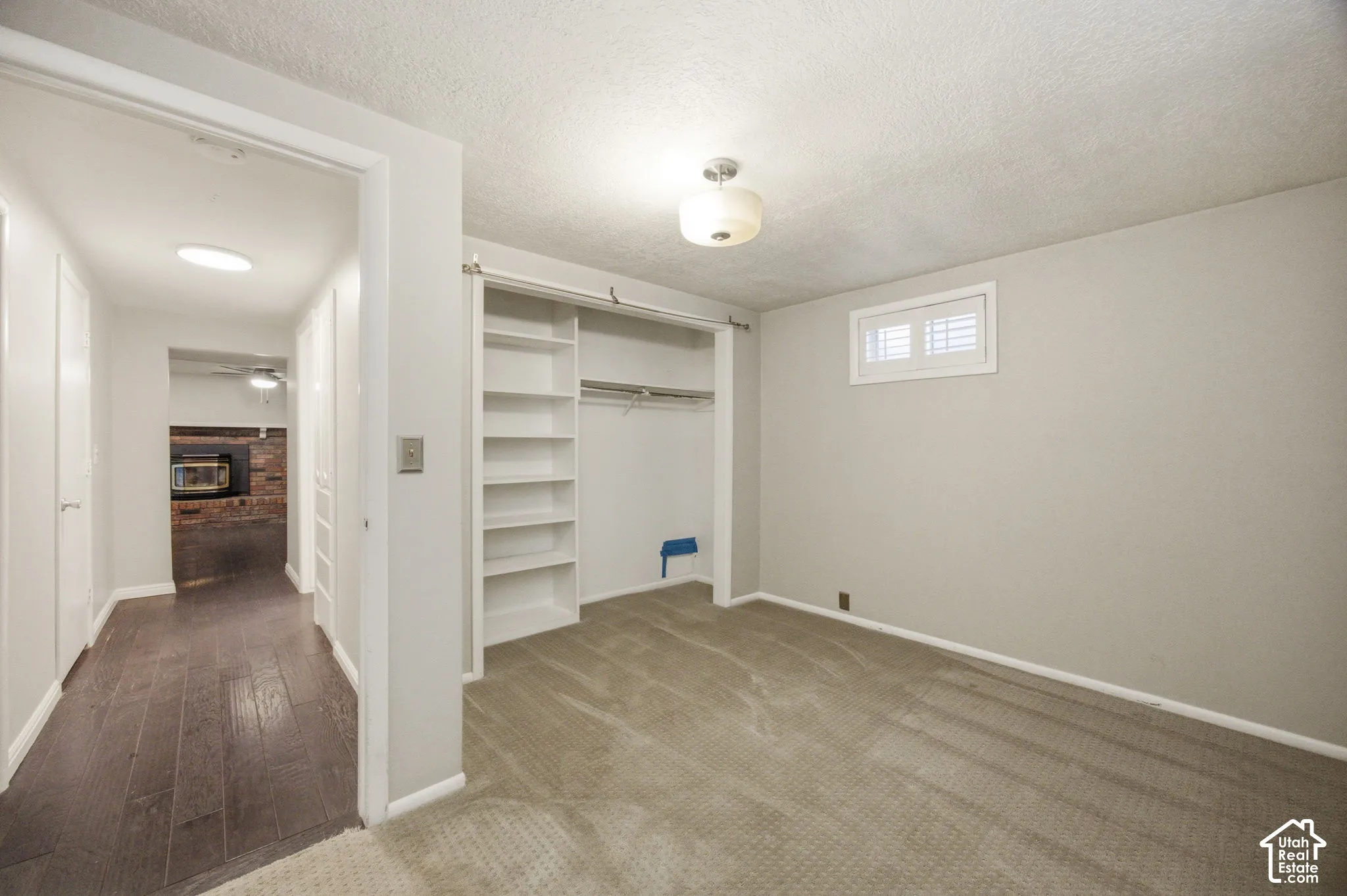 Bedroom #4 featuring neutral wall tones, wall-to-wall carpeting, and a built-in closet system with integrated shelving