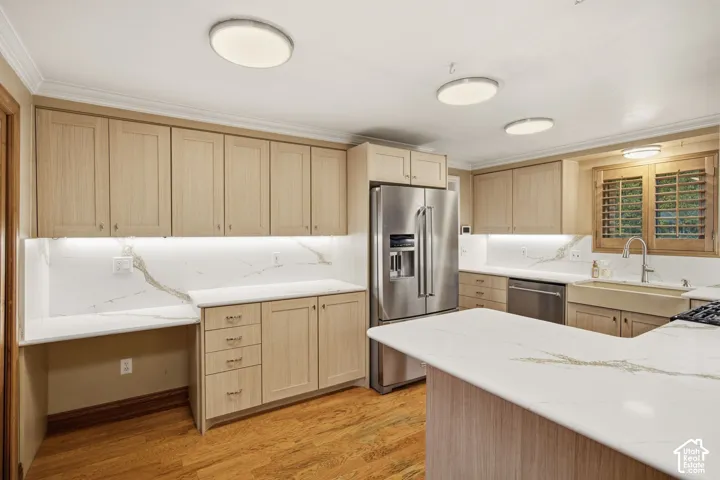 Kitchen featuring light-finish cabinetry, stone-style countertops with veining, an undermount farmhouse sink, stainless steel appliances, and wood-finish flooring