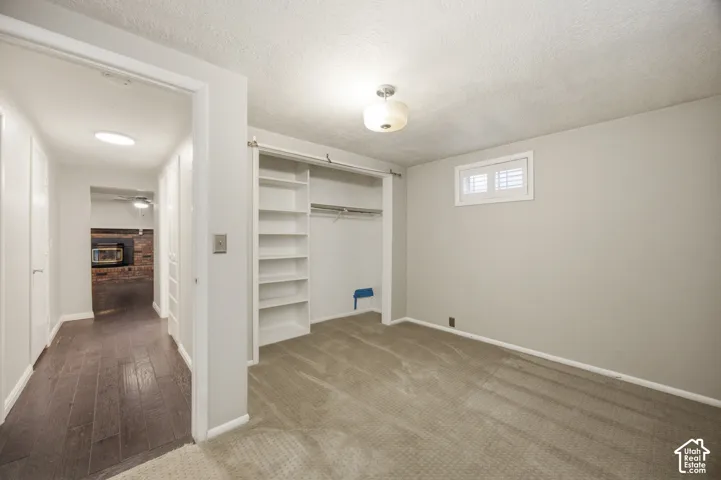 Bedroom #4 featuring neutral wall tones, wall-to-wall carpeting, and a built-in closet system with integrated shelving