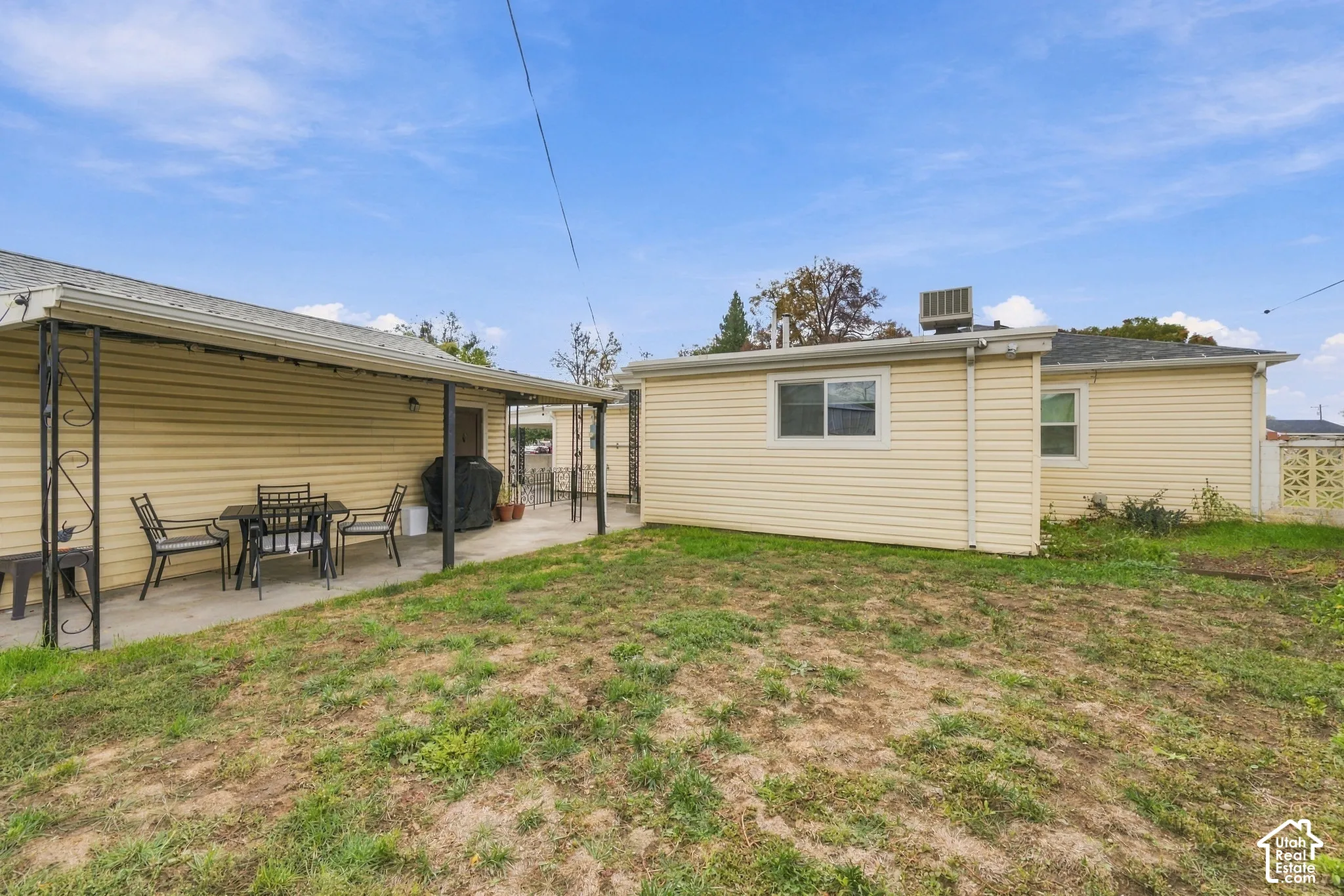 large back yard with covered concrete patio