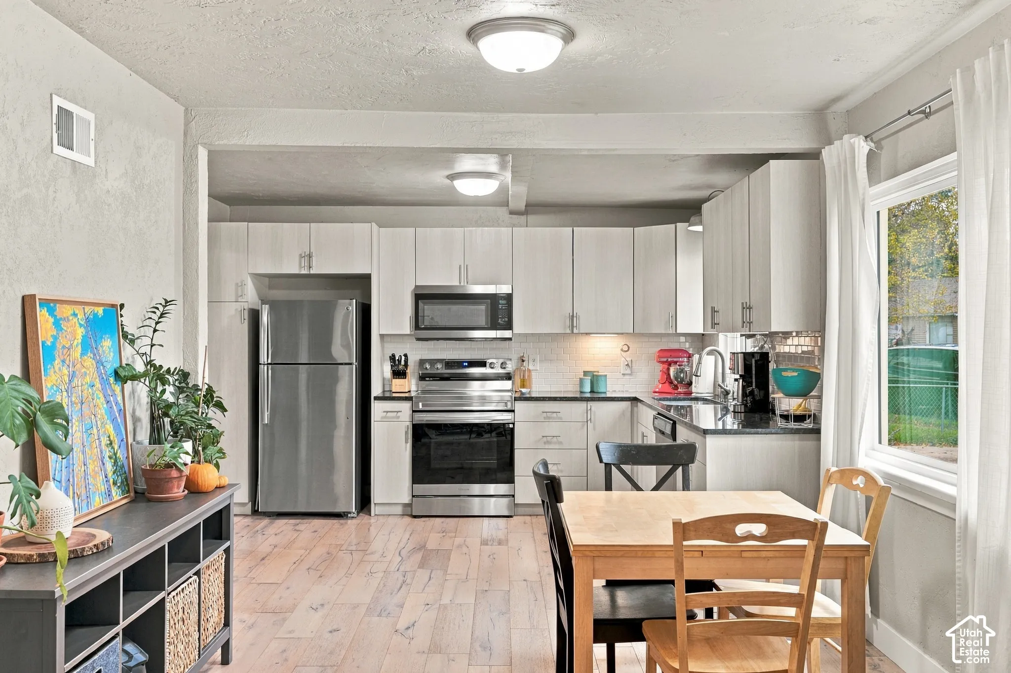 Open Kitchen featuring light-toned cabinetry, stainless steel appliances, wood-finish flooring, and recessed ceiling lighting
