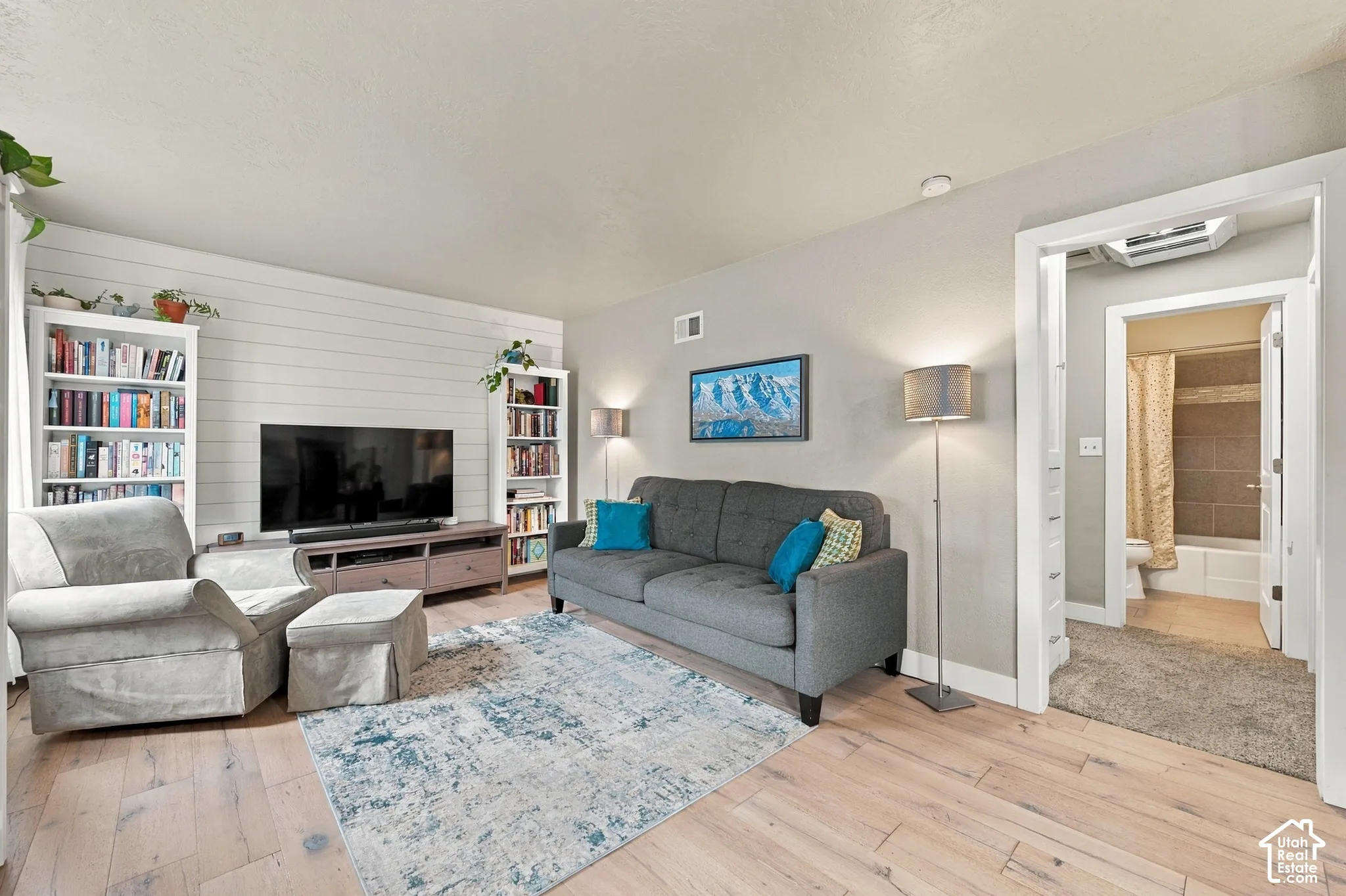 Living area featuring wood-finish flooring, shiplap wall accent
